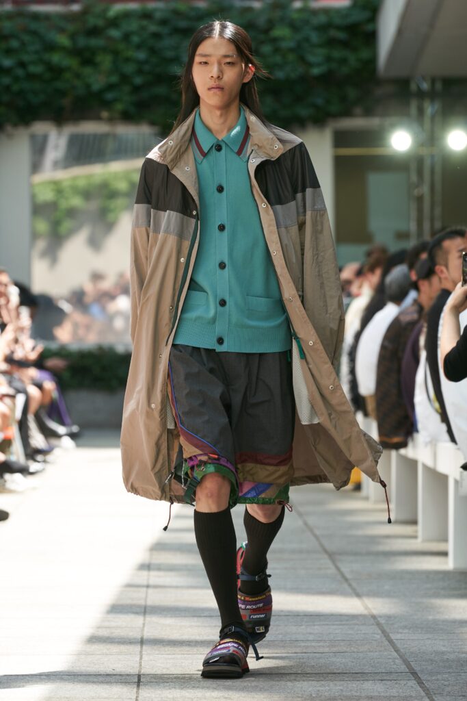 A relaxed beige coat paired with green cotton shorts, featuring a collared long-sleeve design.