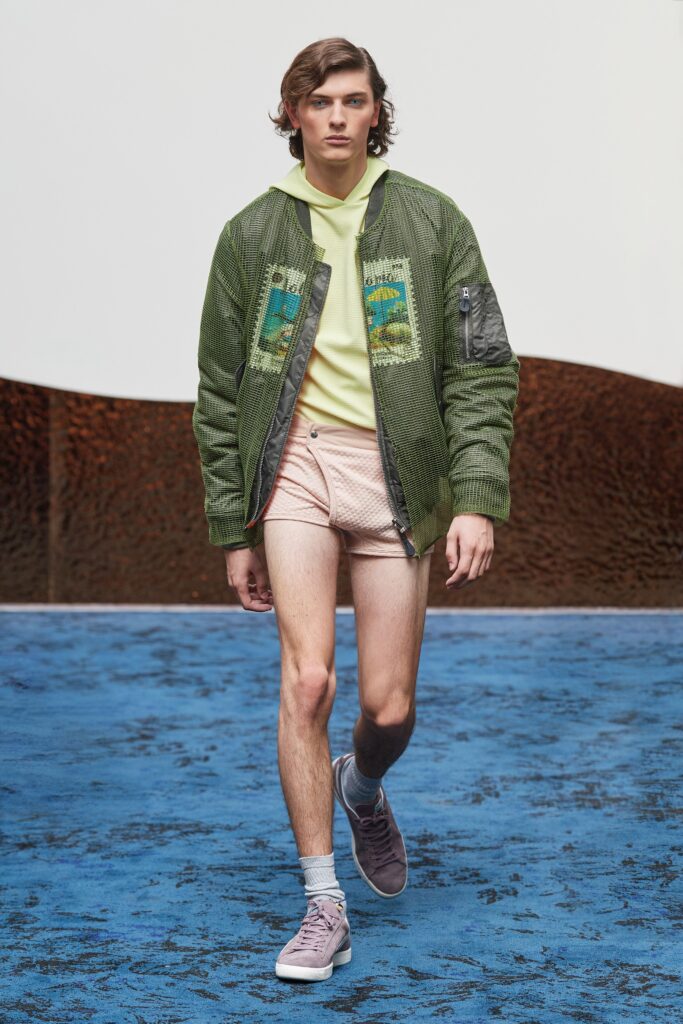 A relaxed fit green jacket with a hood, paired with printed pink shorts.