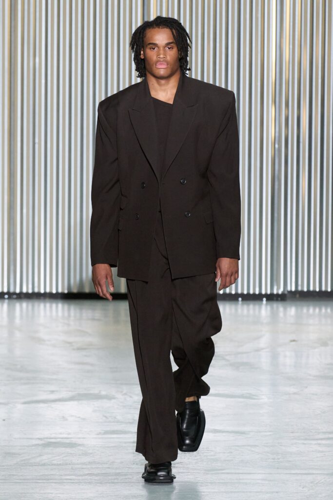 An oversized brown wool suit featuring a collared long-sleeve jacket and buttoned design.