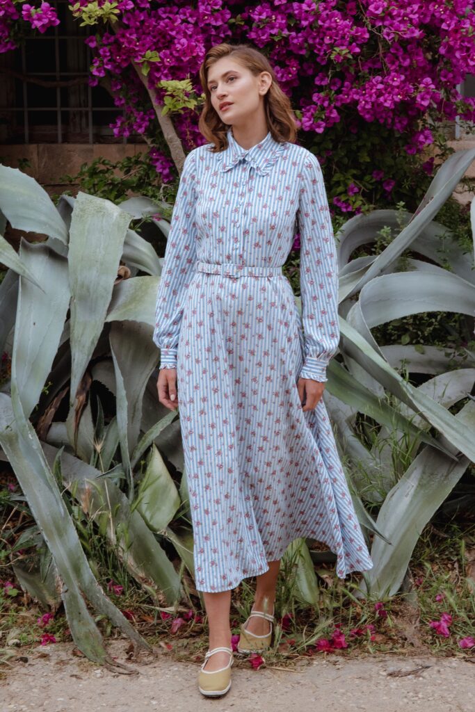 A relaxed blue cotton dress with long sleeves, a collared neckline, and a printed design.