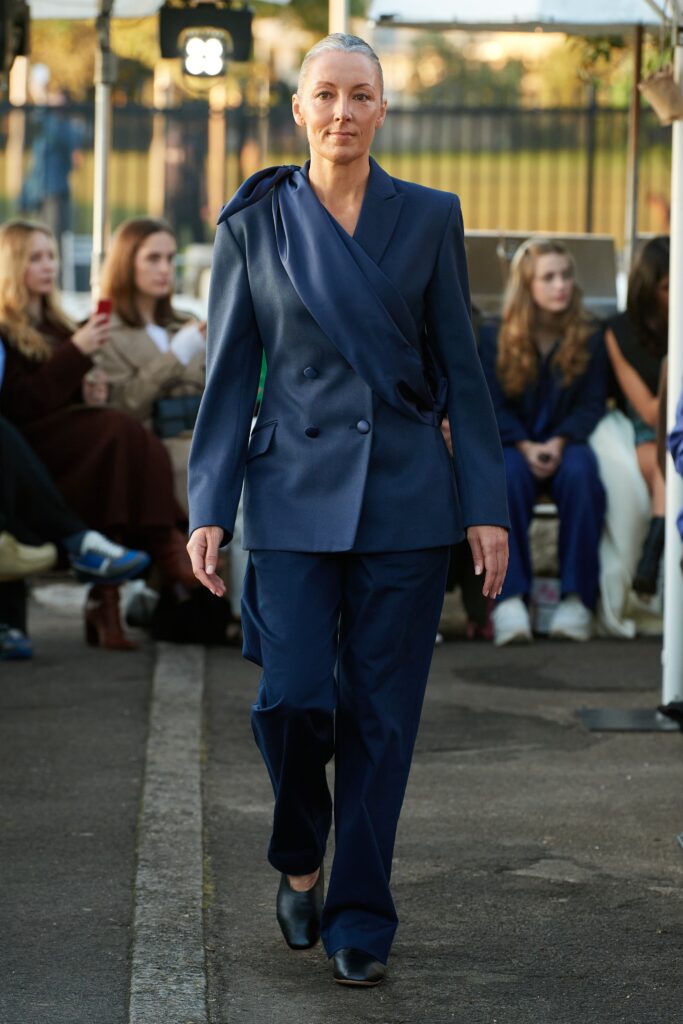 A fitted blue blazer with an asymmetric design paired with matching pants.
