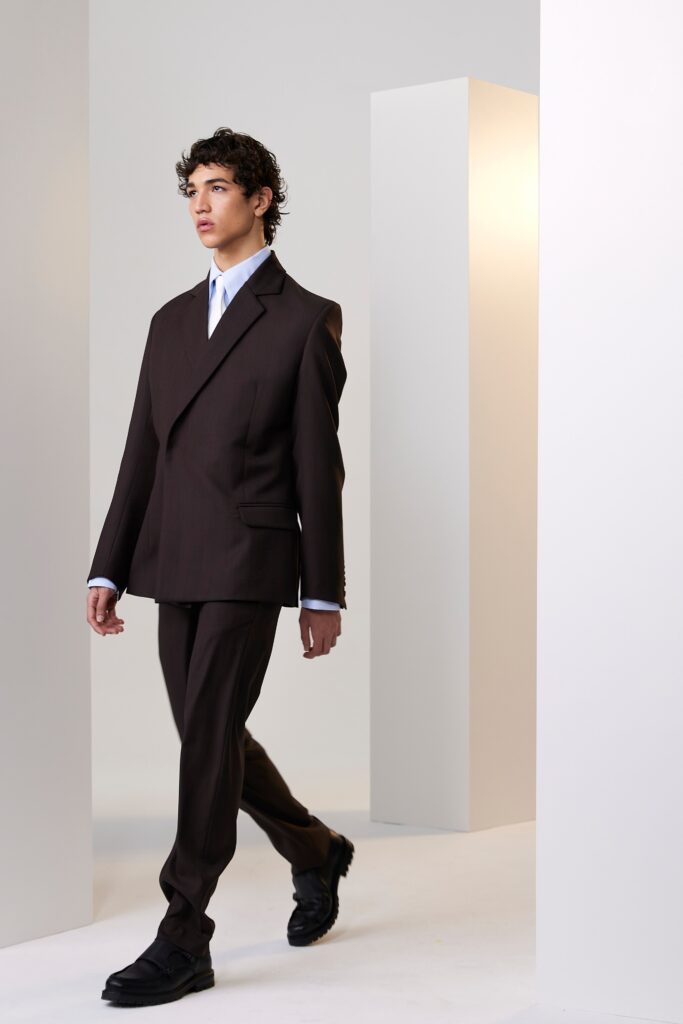 A tailored brown suit with long sleeves and a collared shirt, featuring buttoned details.