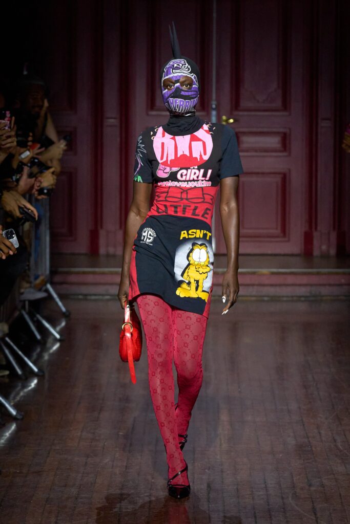 A fitted black and red printed dress with a short-sleeve design and asymmetric details.