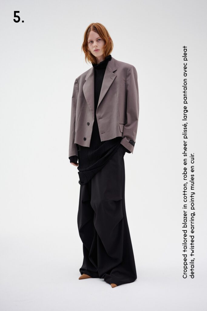 A relaxed gray jacket paired with wide-leg black pants featuring pleated details.