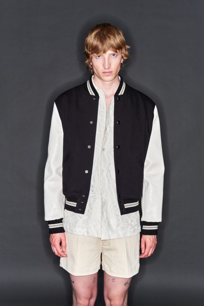 A relaxed black and white jacket paired with beige shorts featuring a collared, short-sleeve design.