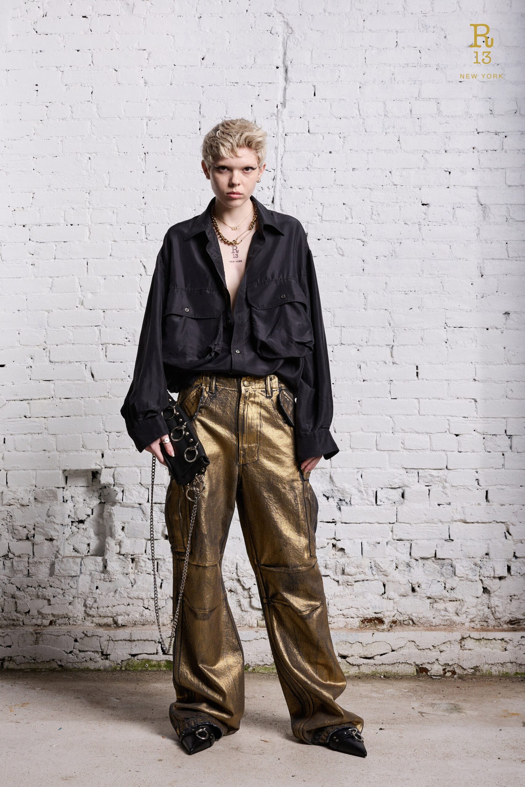 A relaxed black long-sleeve collared shirt paired with wide-leg gold pants.