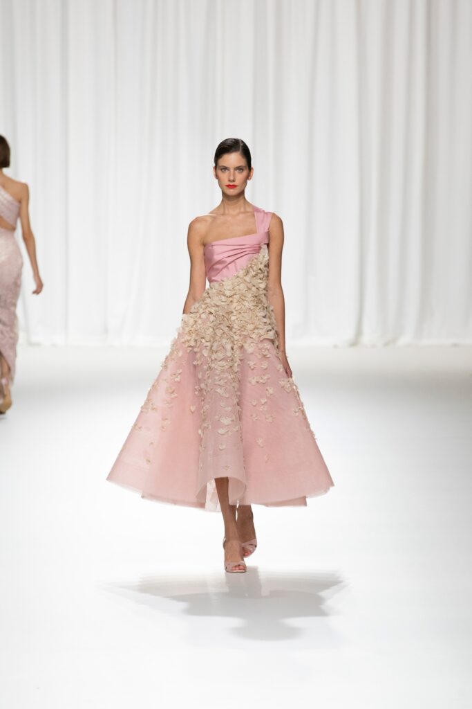 A fitted pink silk dress with a sleeveless design and layered details.