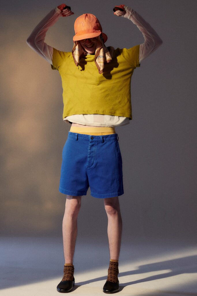 A relaxed yellow short-sleeve top paired with blue shorts, creating a casual summer look.