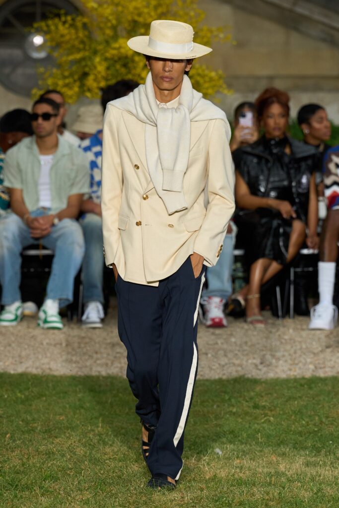 A tailored beige suit with a collared long-sleeve shirt and navy pants.