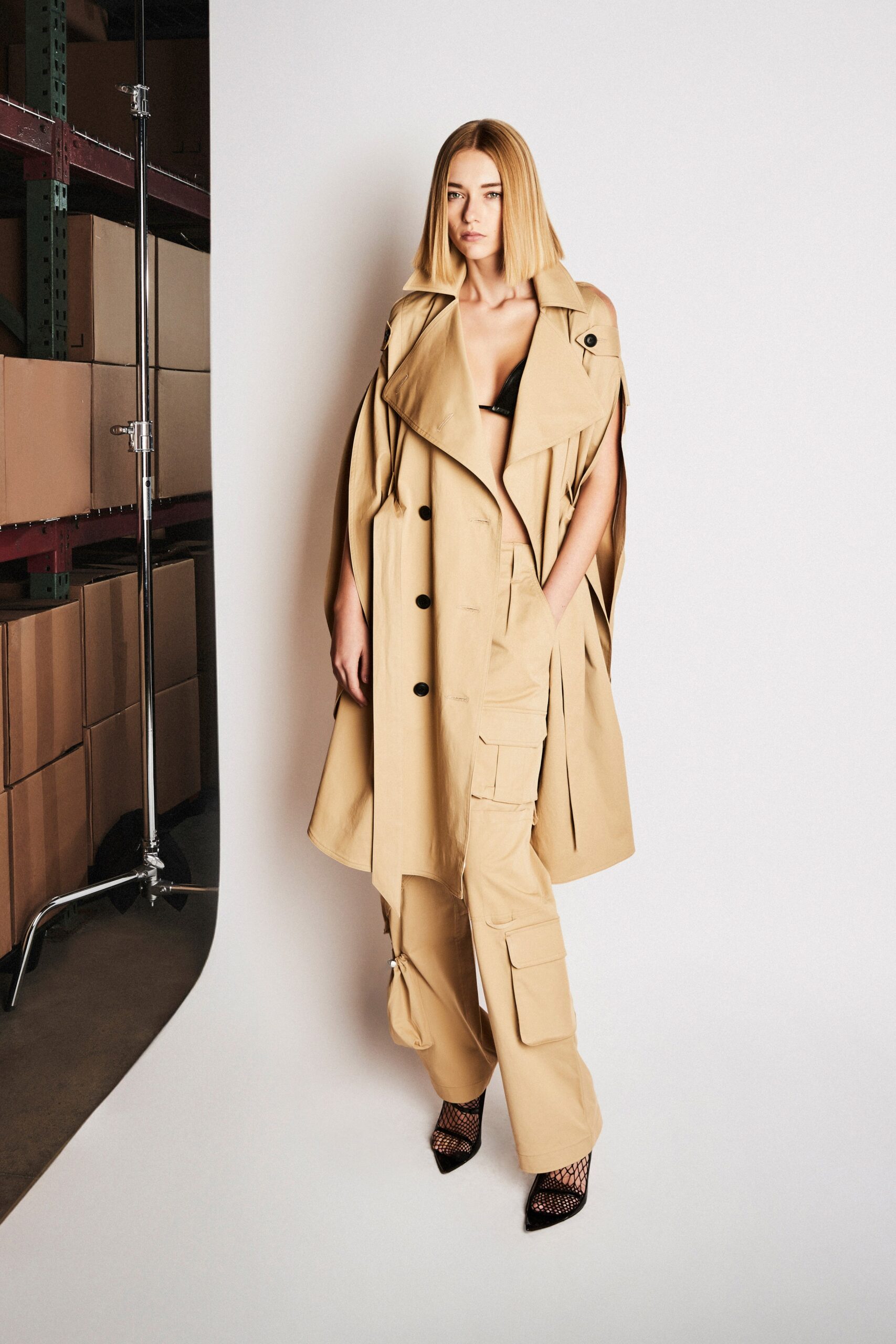A relaxed beige cotton trench coat with long sleeves and wide-leg pants.
