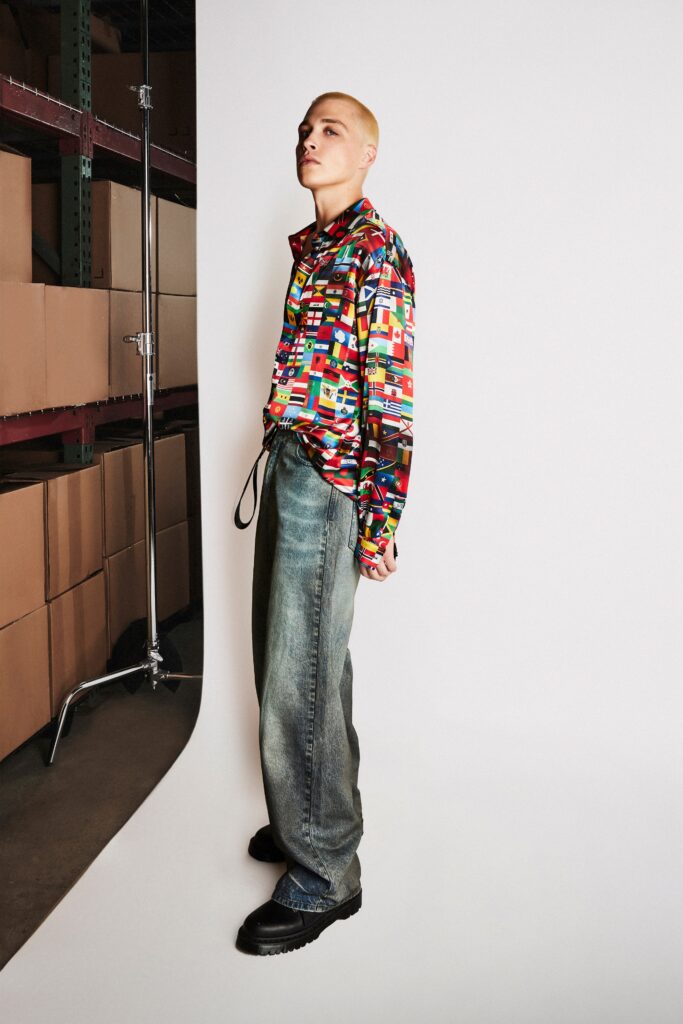 A relaxed-fit multicolor printed shirt paired with wide-leg blue denim pants.