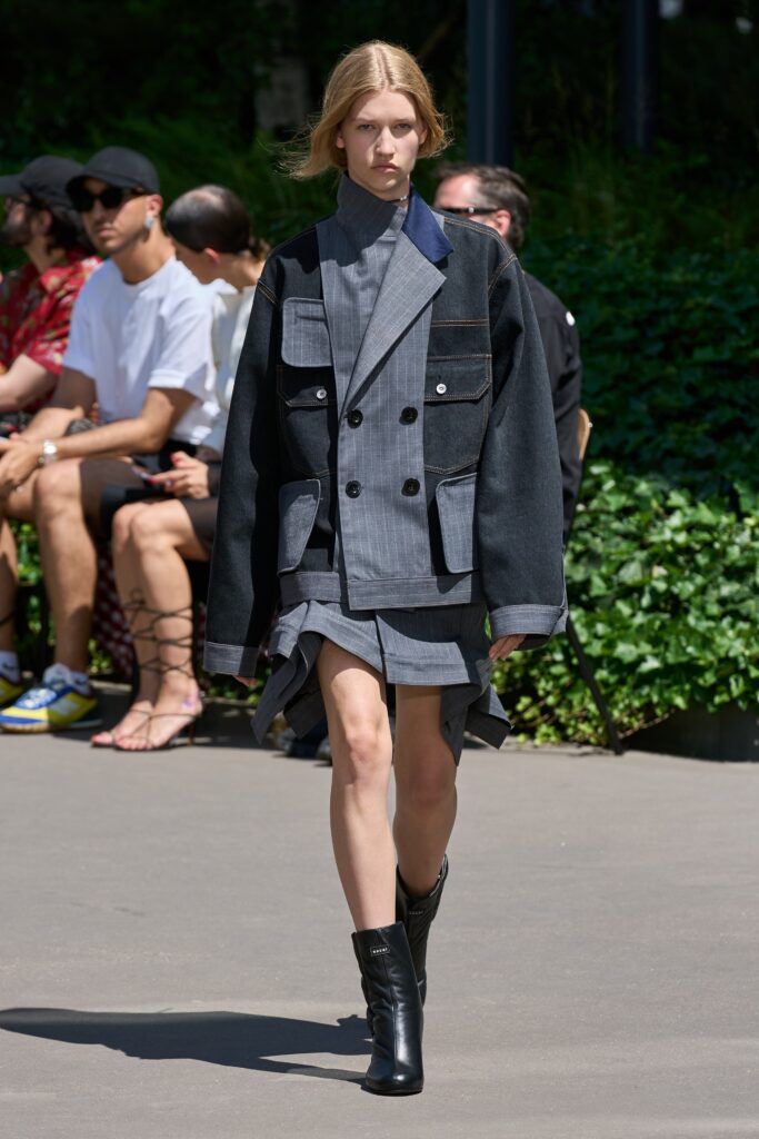 A fitted black and gray dress with a collared jacket featuring an asymmetric design.