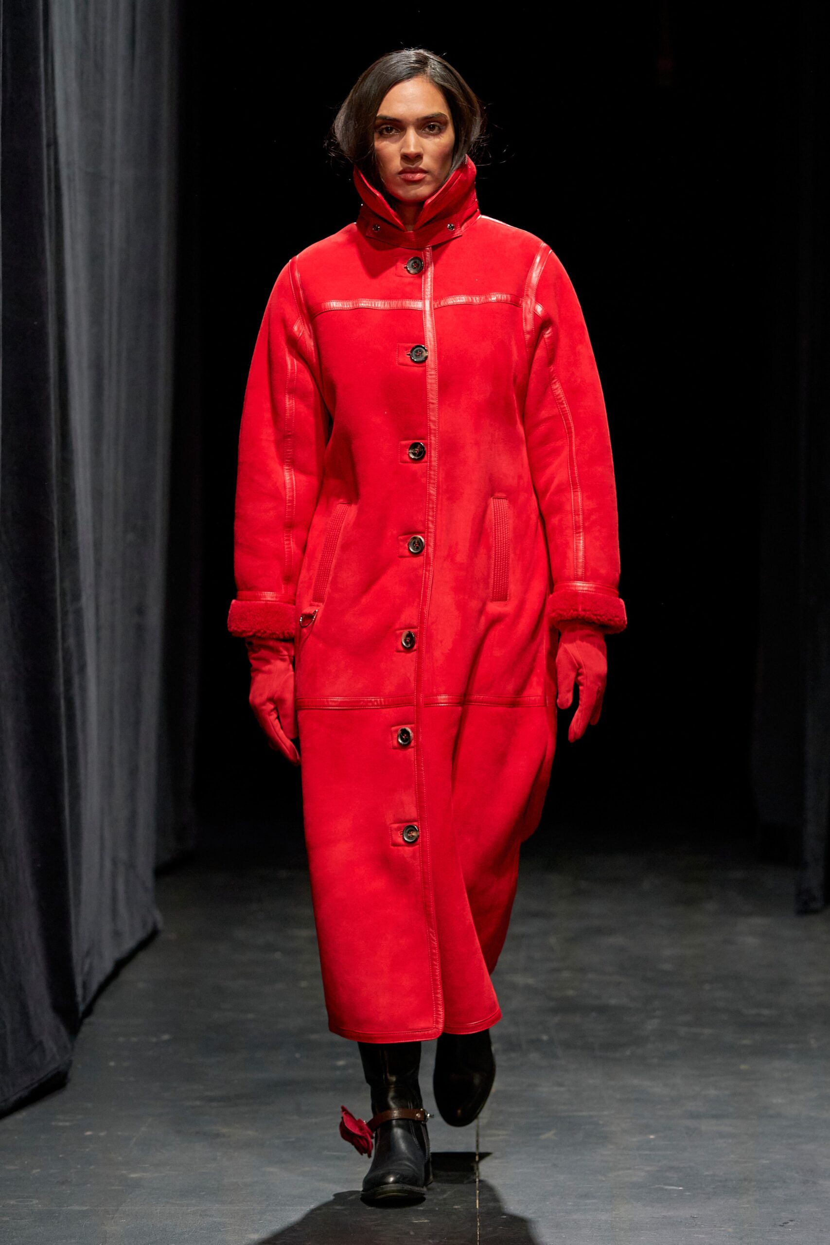 A fitted red leather coat with long sleeves and a collared design, featuring button details.