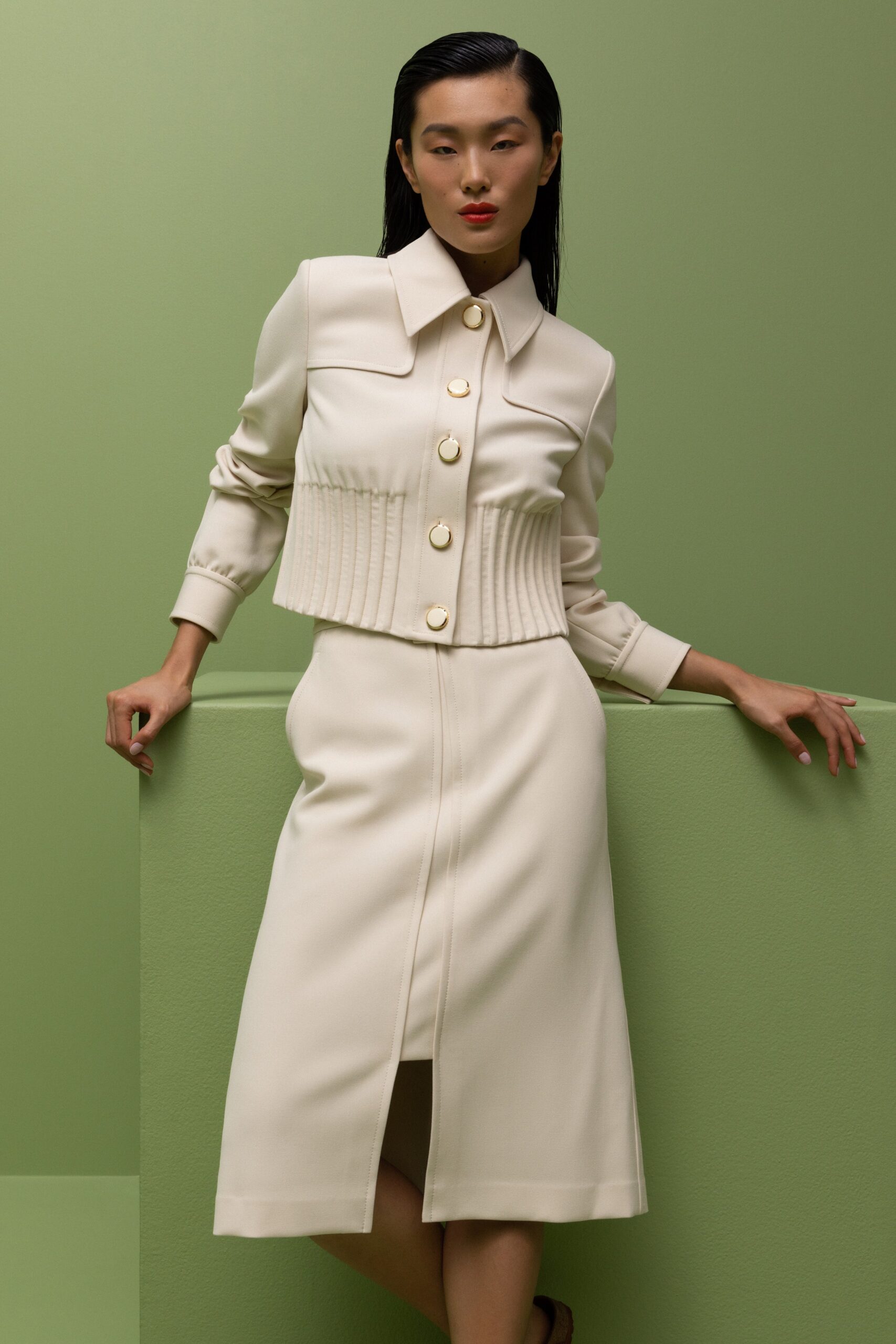 A fitted beige dress paired with a collared long-sleeve jacket featuring button details.