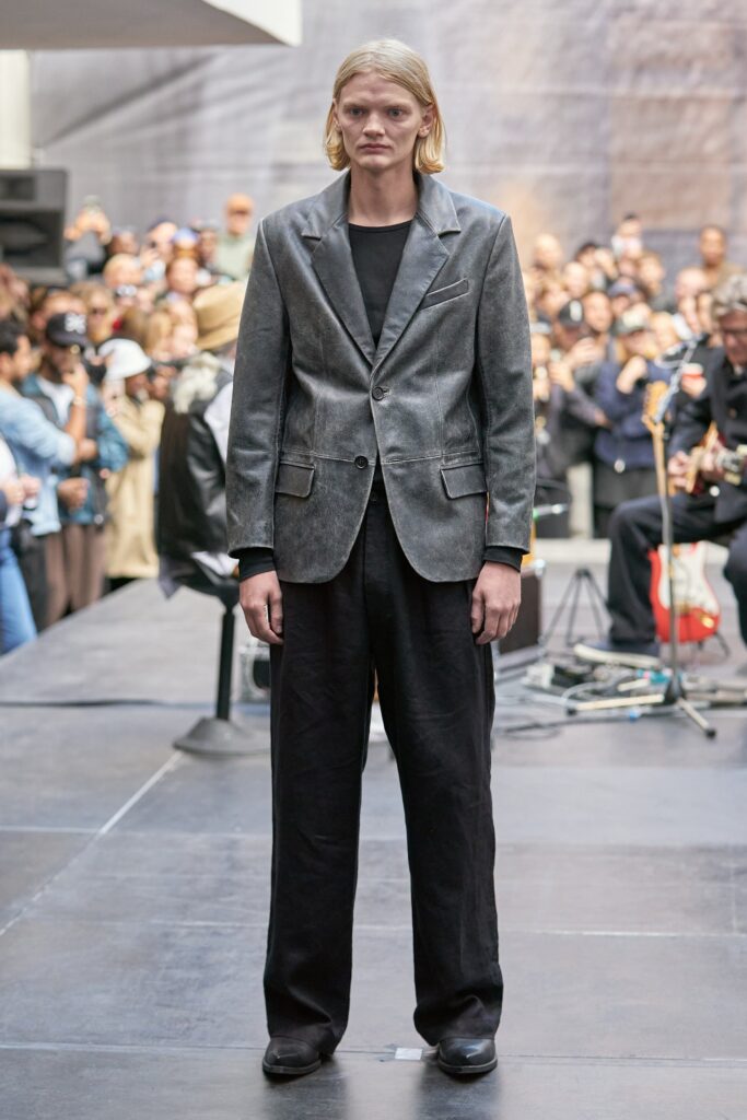 A relaxed-fit gray cotton blazer paired with black straight-leg pants, featuring a collared design.