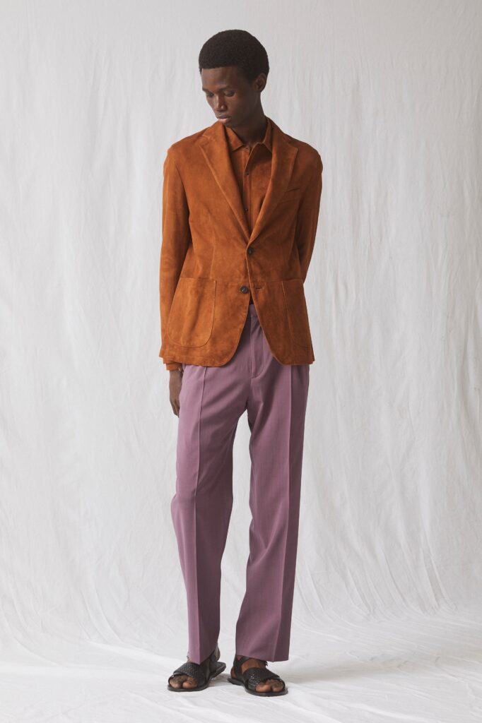 A tailored brown suede blazer paired with straight-leg purple pants for a sophisticated look.