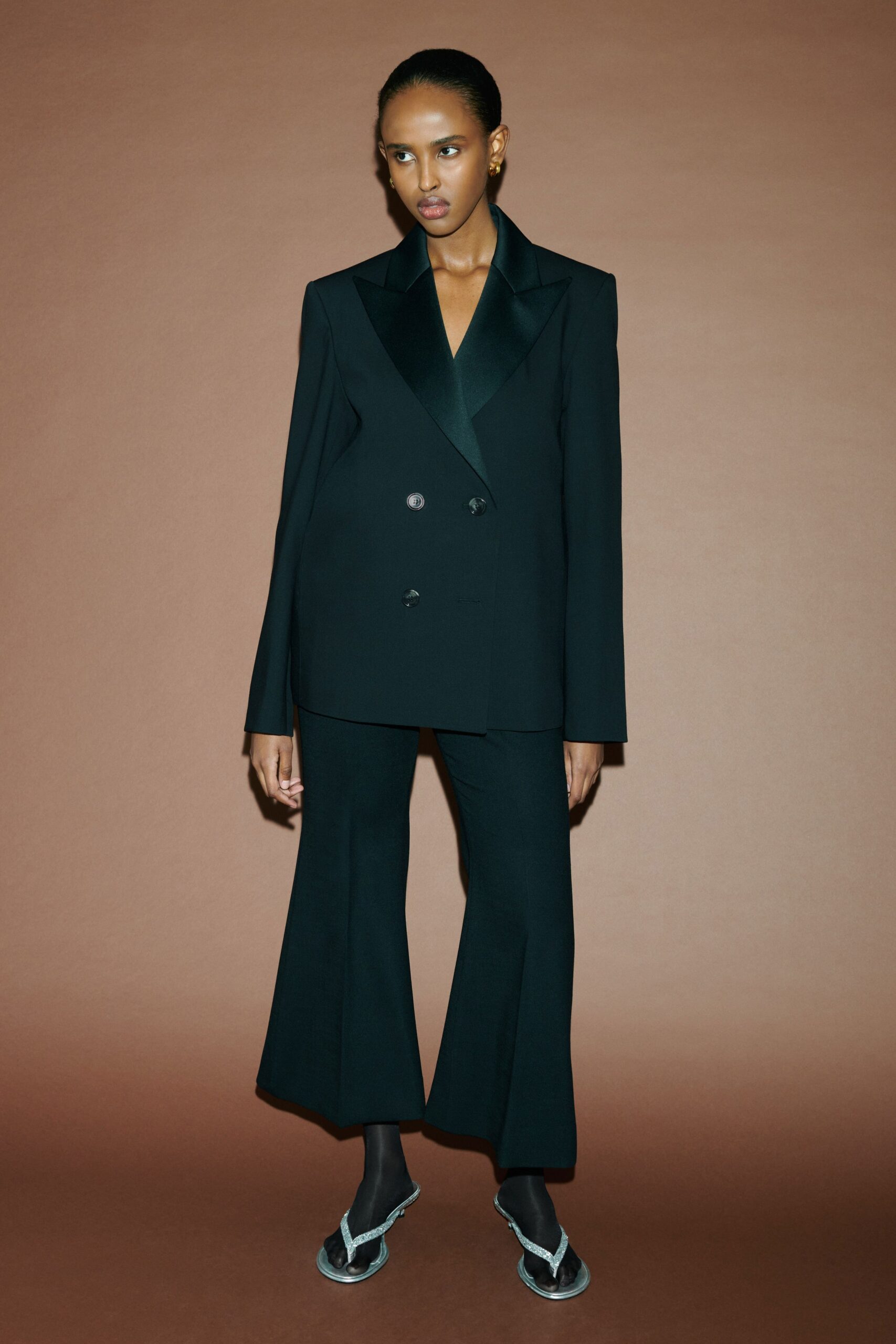 A tailored black blazer with long sleeves and flared pants, creating a sophisticated look.