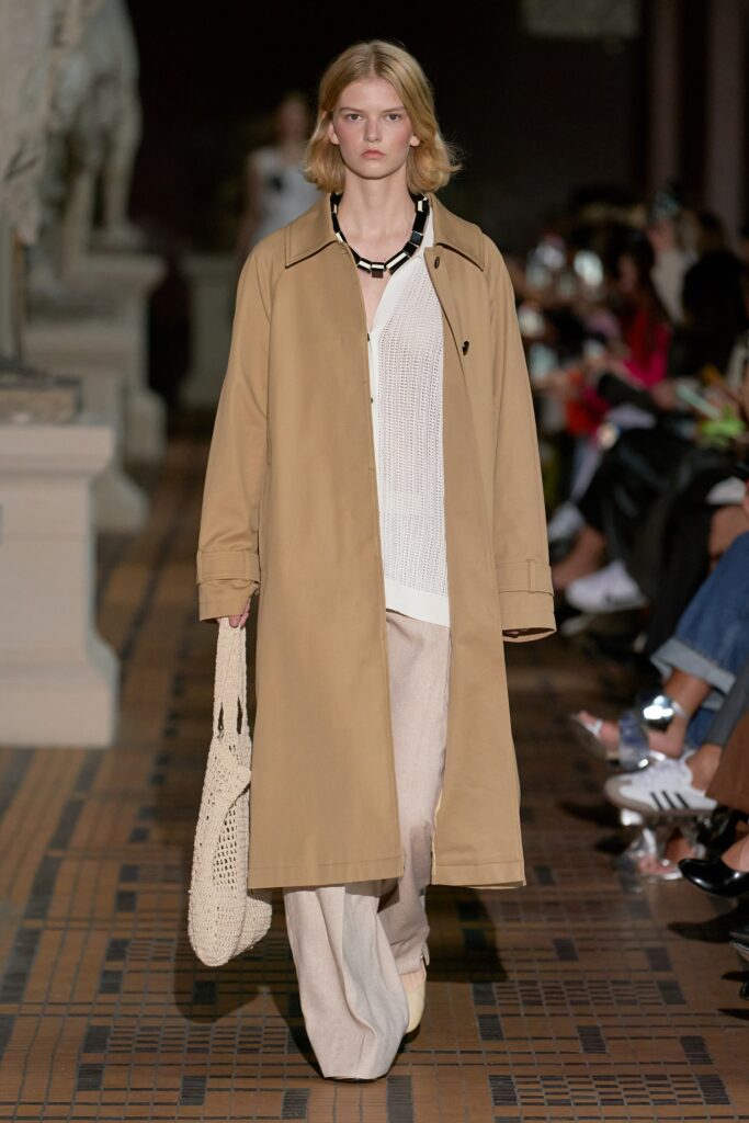A relaxed beige cotton coat with long sleeves and a collared design, paired with matching pants.
