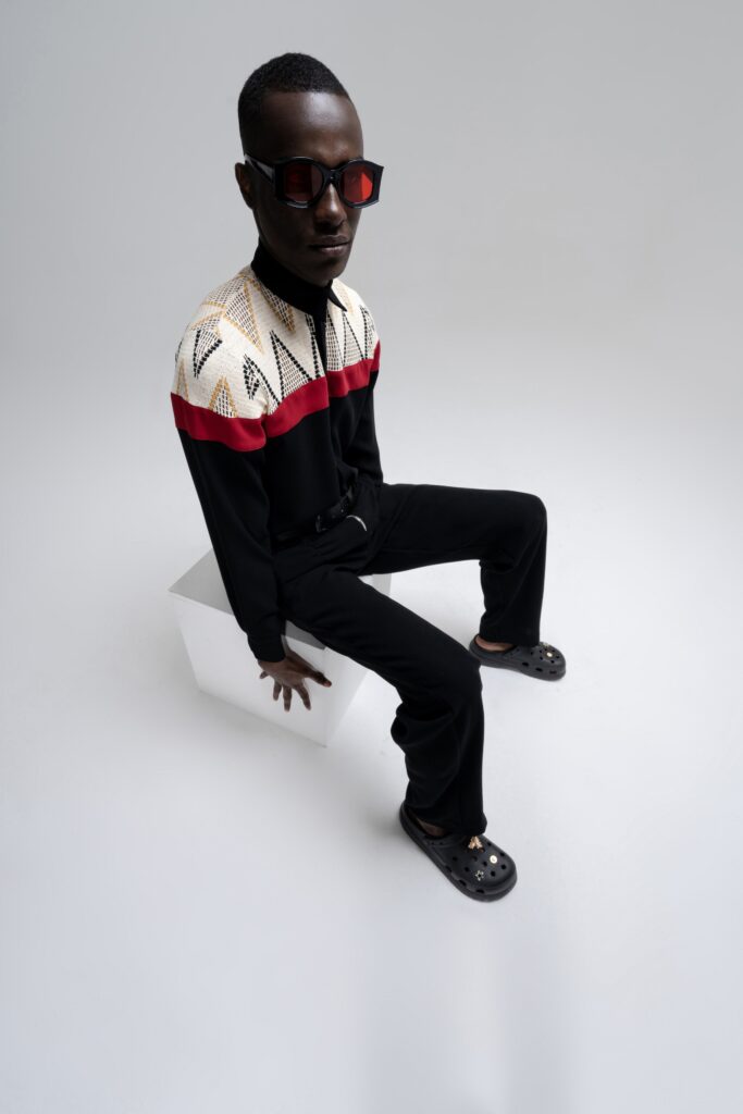 A fitted black long-sleeve shirt with a printed design paired with black pants.
