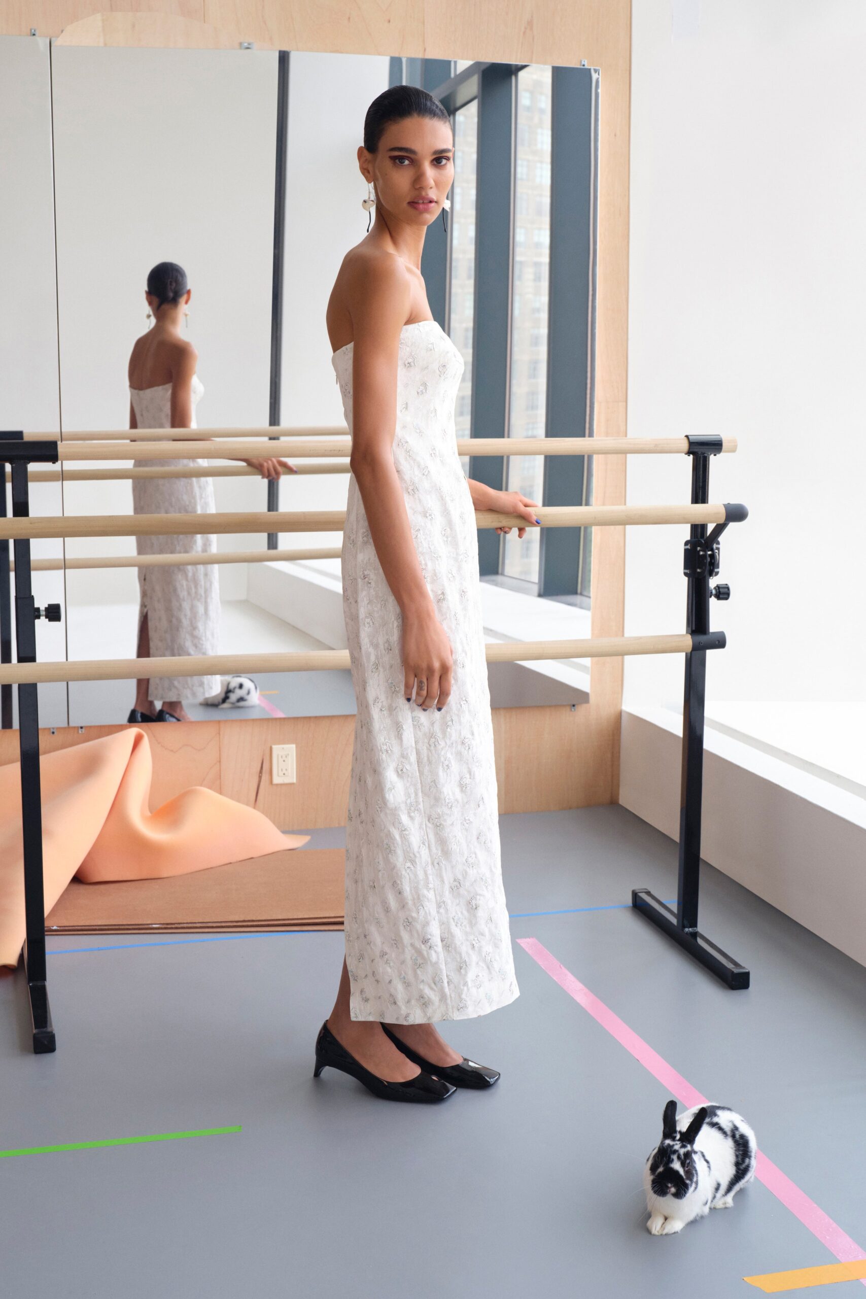 A fitted white silk strapless gown featuring intricate embroidery for an elegant look.