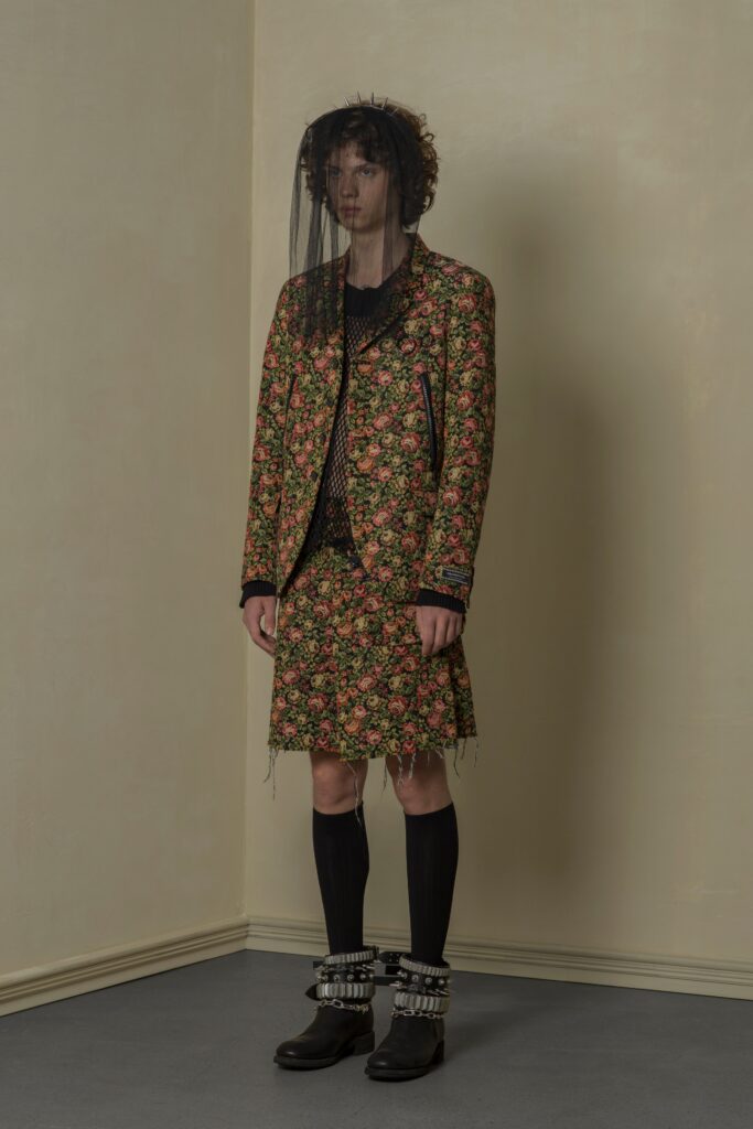 A fitted multicolor floral jacket with a collared neckline paired with a matching skirt.