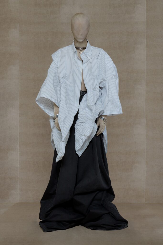 An oversized black and white collared top with short sleeves and an asymmetric layered skirt.