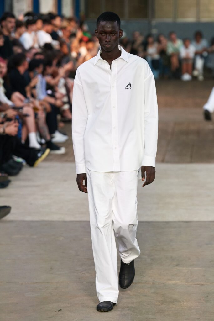 A relaxed white long-sleeve collared shirt paired with straight-leg pants.