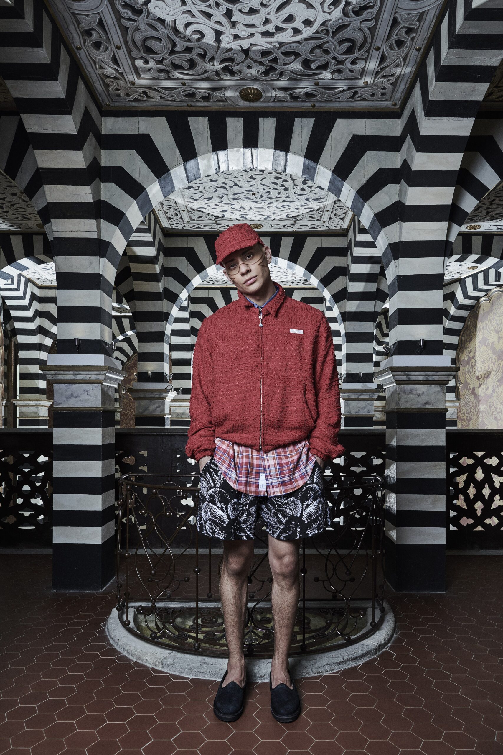 A relaxed-fit red cotton jacket with a collared neckline paired with printed black shorts.