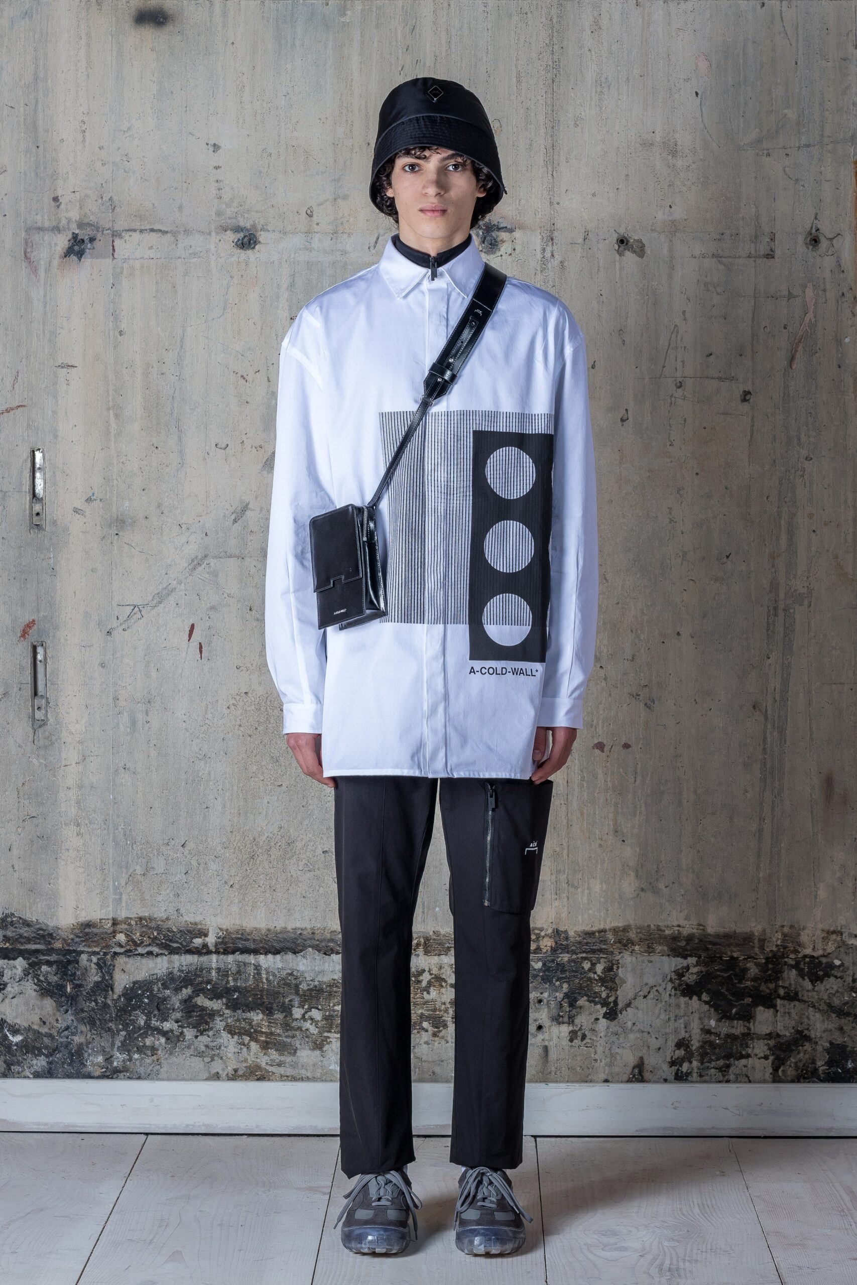 A relaxed fit white printed shirt with long sleeves paired with black pants.