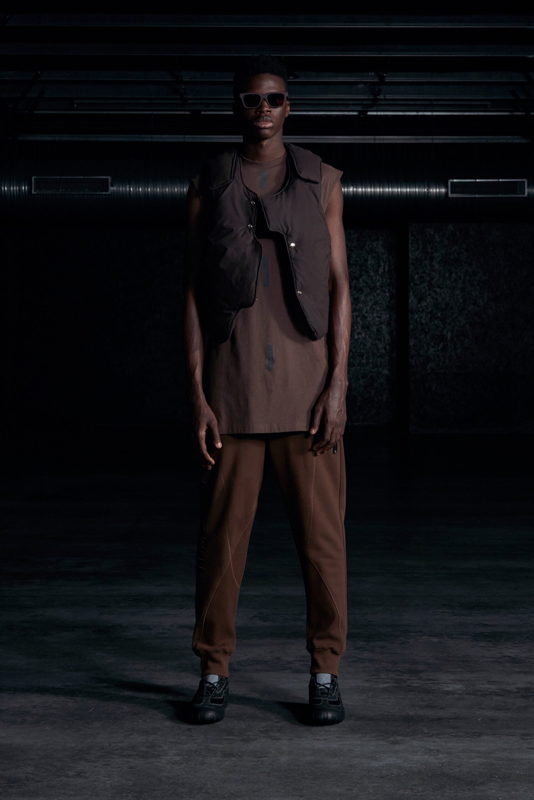 A relaxed brown sleeveless top with a collared design paired with matching pants.