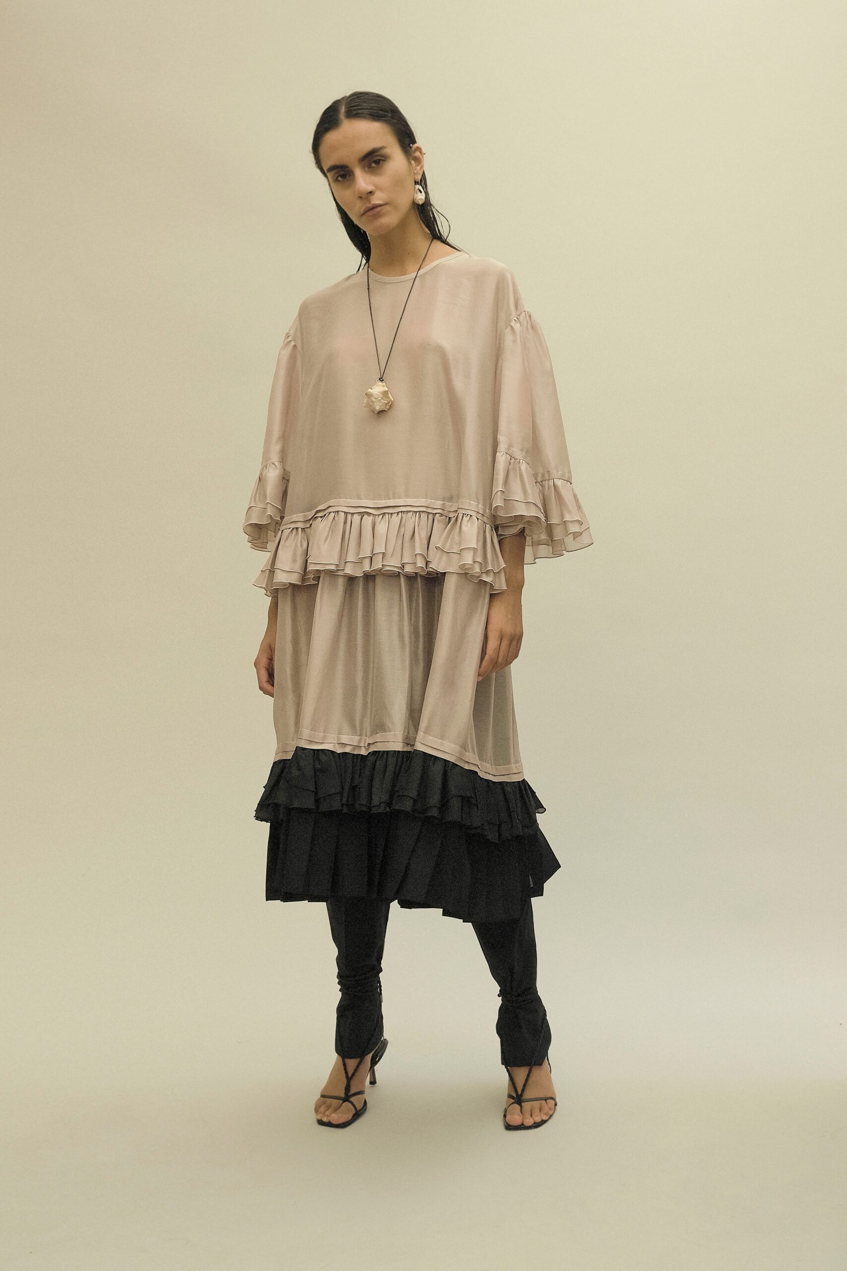 pink ruffled midi dress with black pants
