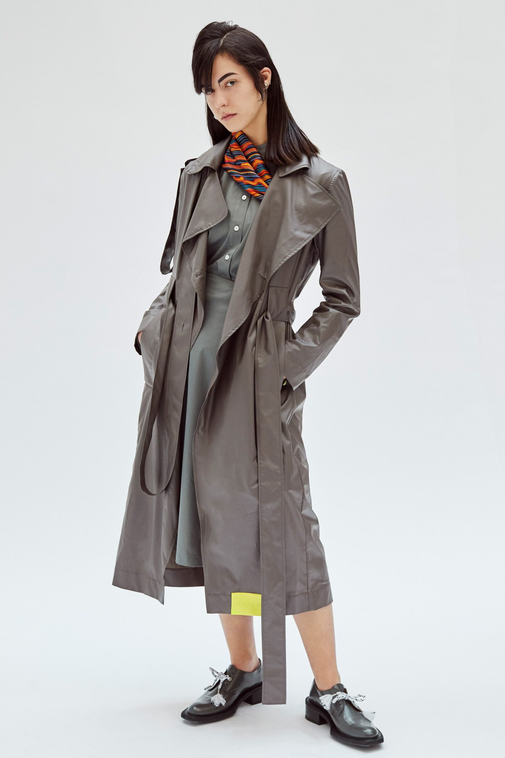 gray vinyl trench coat and green dress