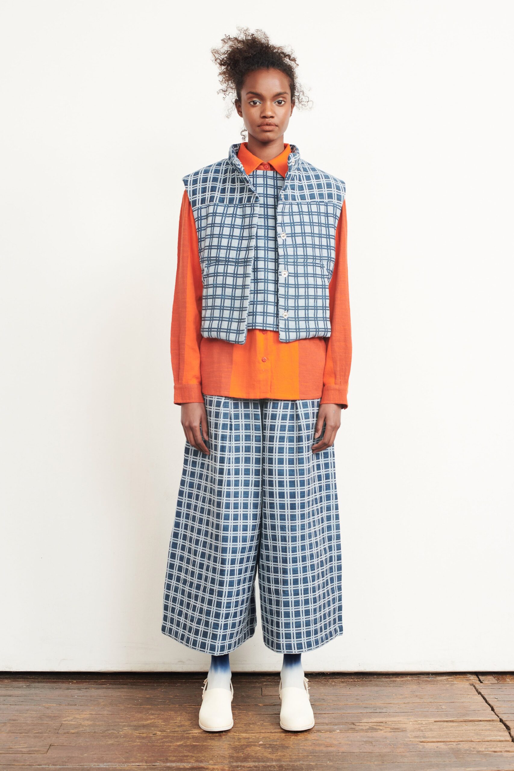 blue and white checked vest with orange shirt