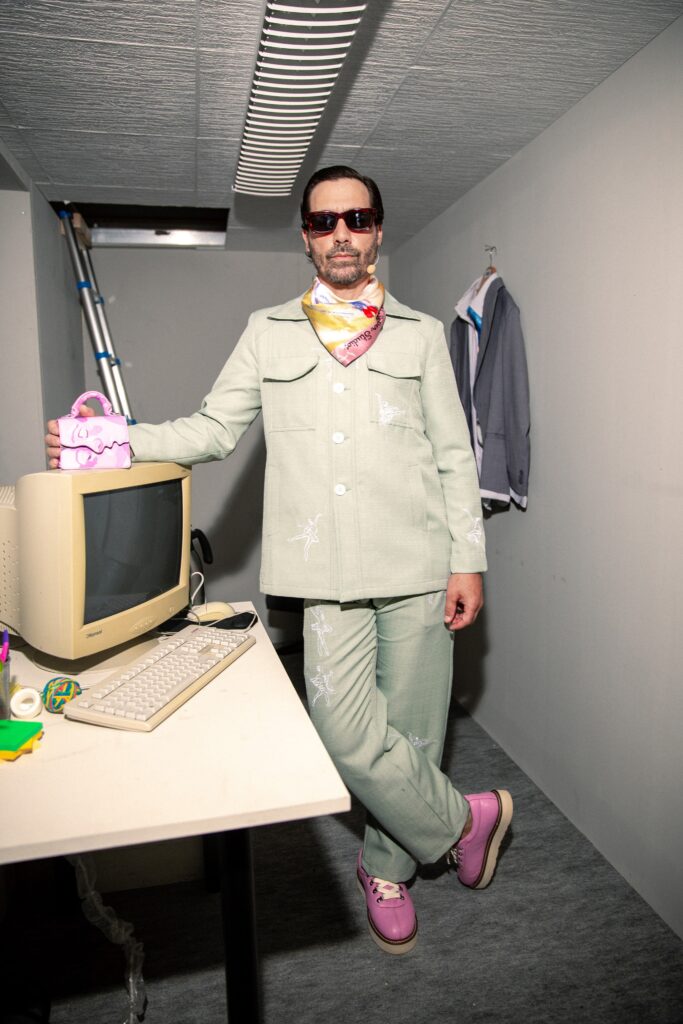 A tailored green cotton suit with long sleeves and a collared design, featuring button details.