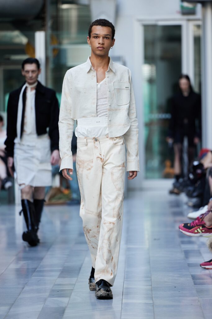 A fitted white cotton jacket with long sleeves paired with matching pants, featuring a modern design.