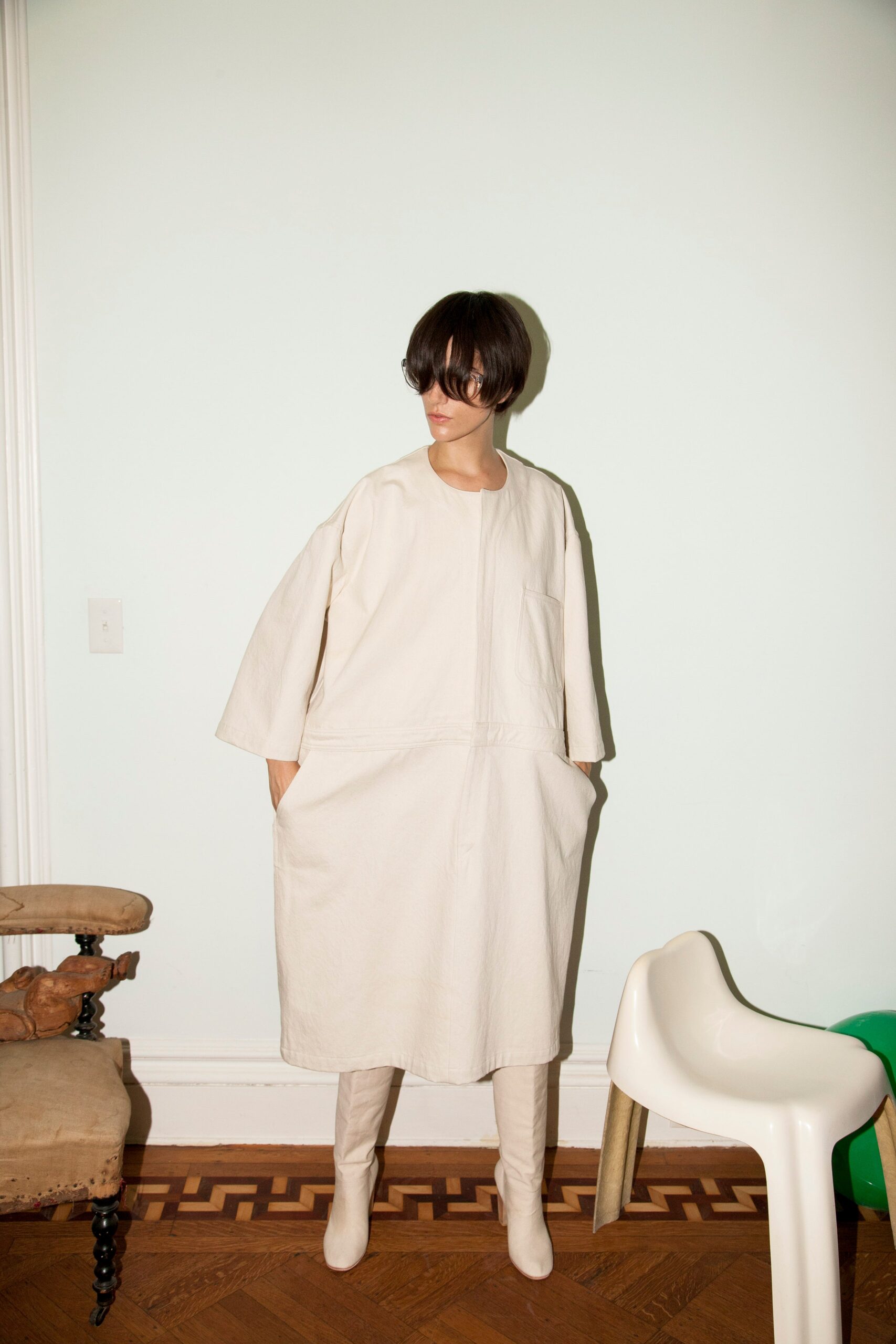 A relaxed beige cotton dress with long sleeves and a collared neckline.