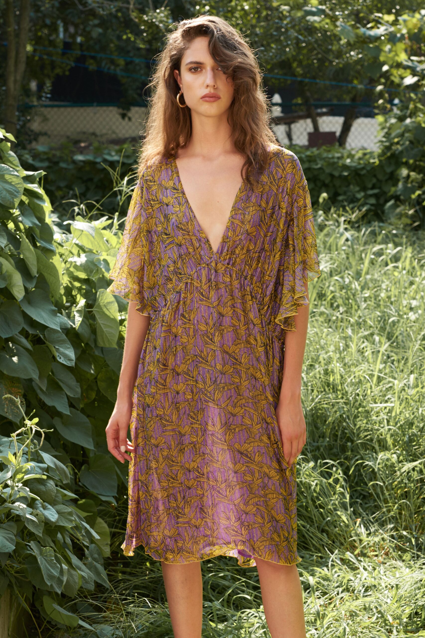 A relaxed purple and yellow printed dress with a V-neckline and short sleeves.