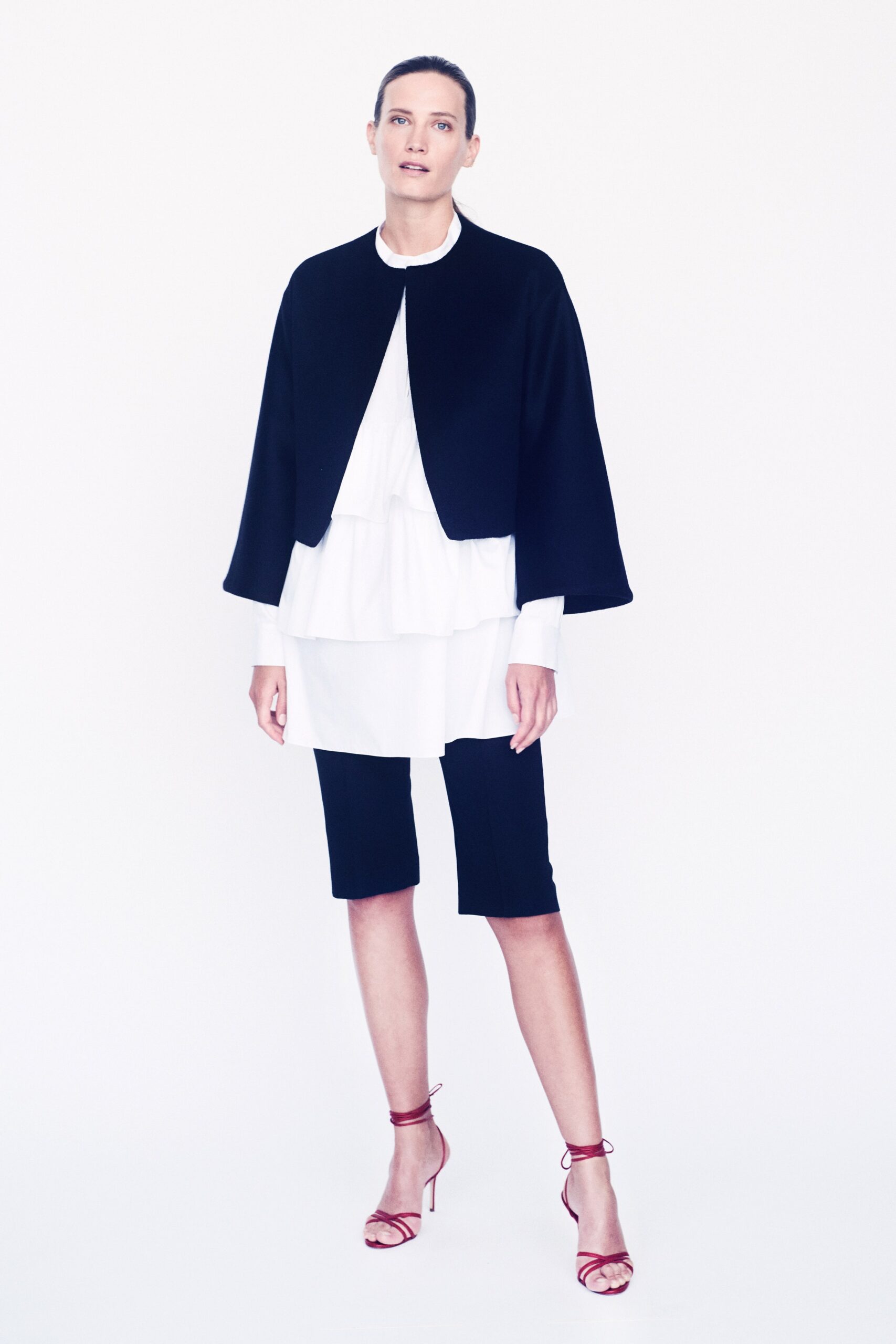 black cape white blouse black shorts