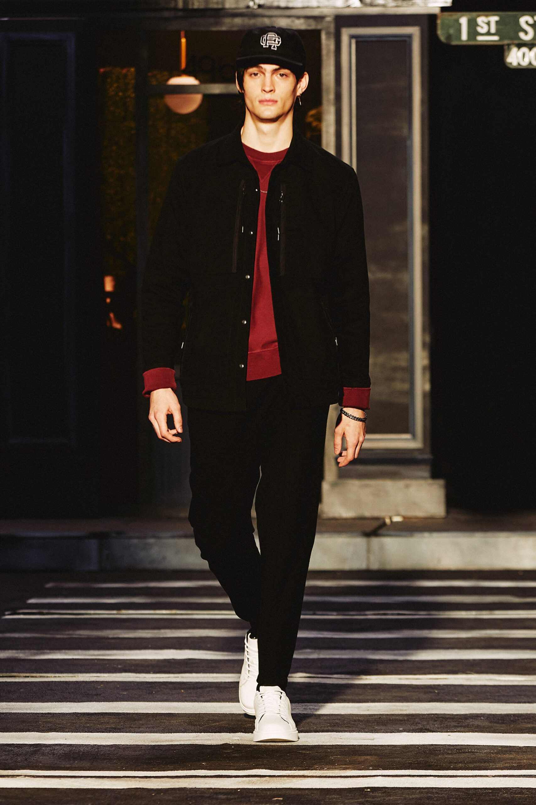 A fitted black jacket with long sleeves and a collared design, paired with black pants.