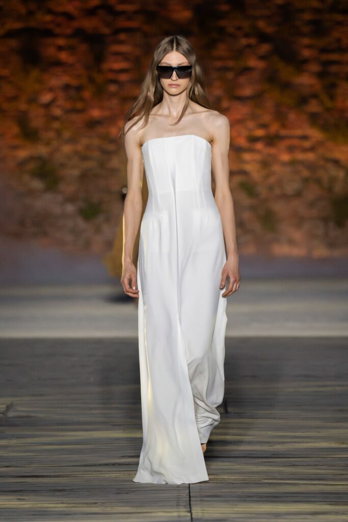 A fitted white silk strapless dress with a maxi silhouette, perfect for elegant occasions.