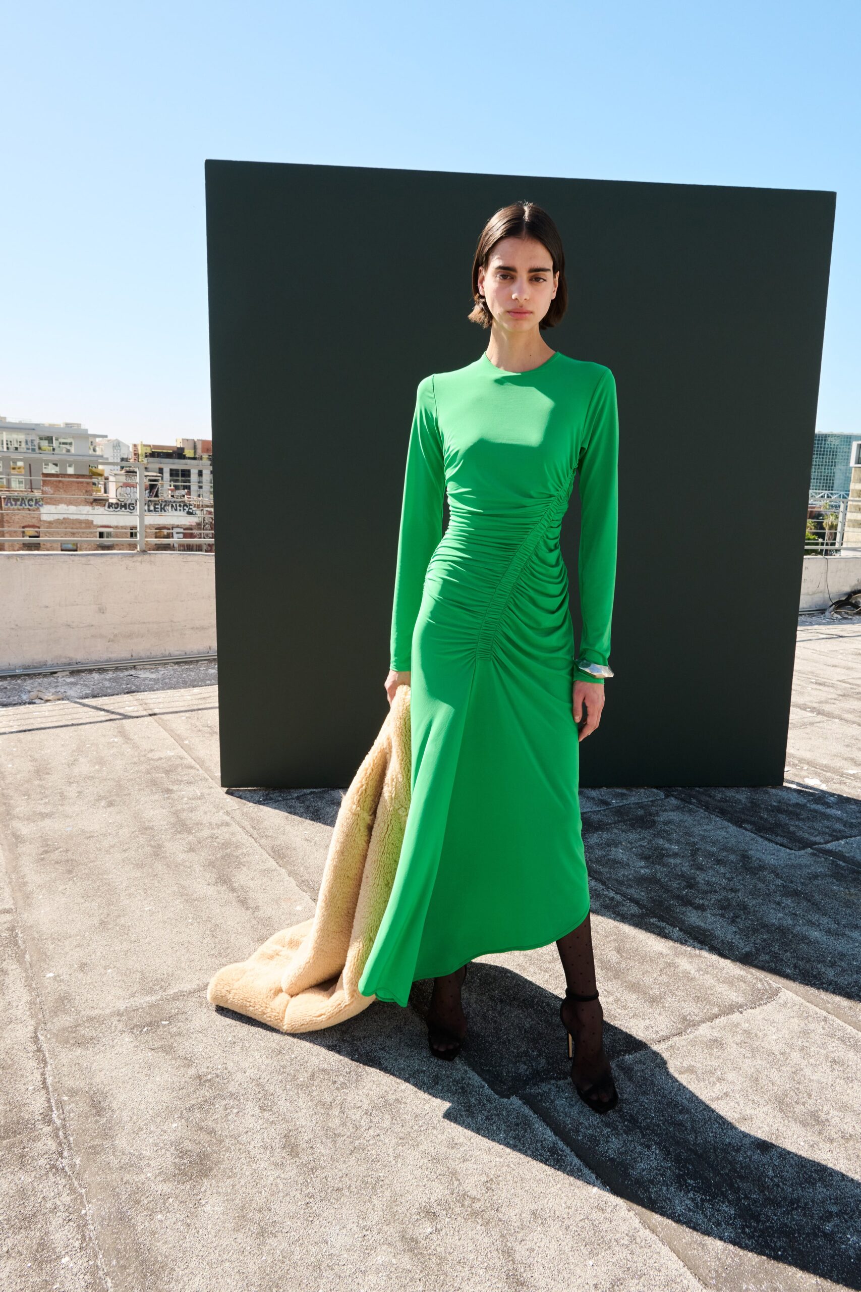 fitted green midi dress with beige coat