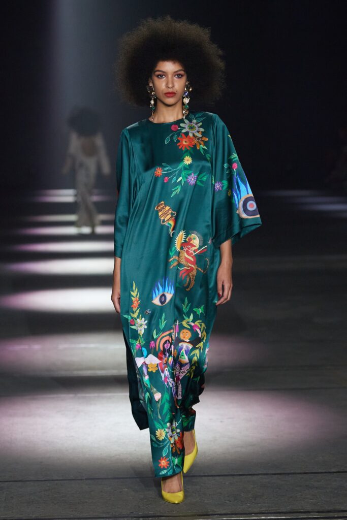A relaxed green silk dress with a high neckline and vibrant printed designs.