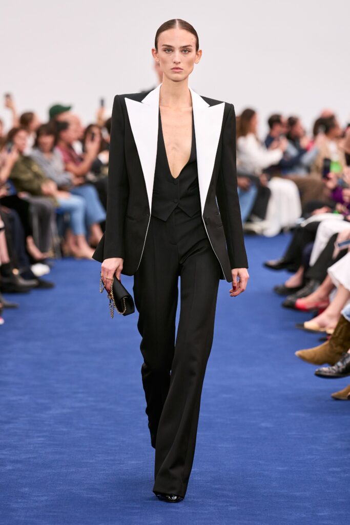 A fitted black and white suit with a deep V-neckline and tailored silhouette.