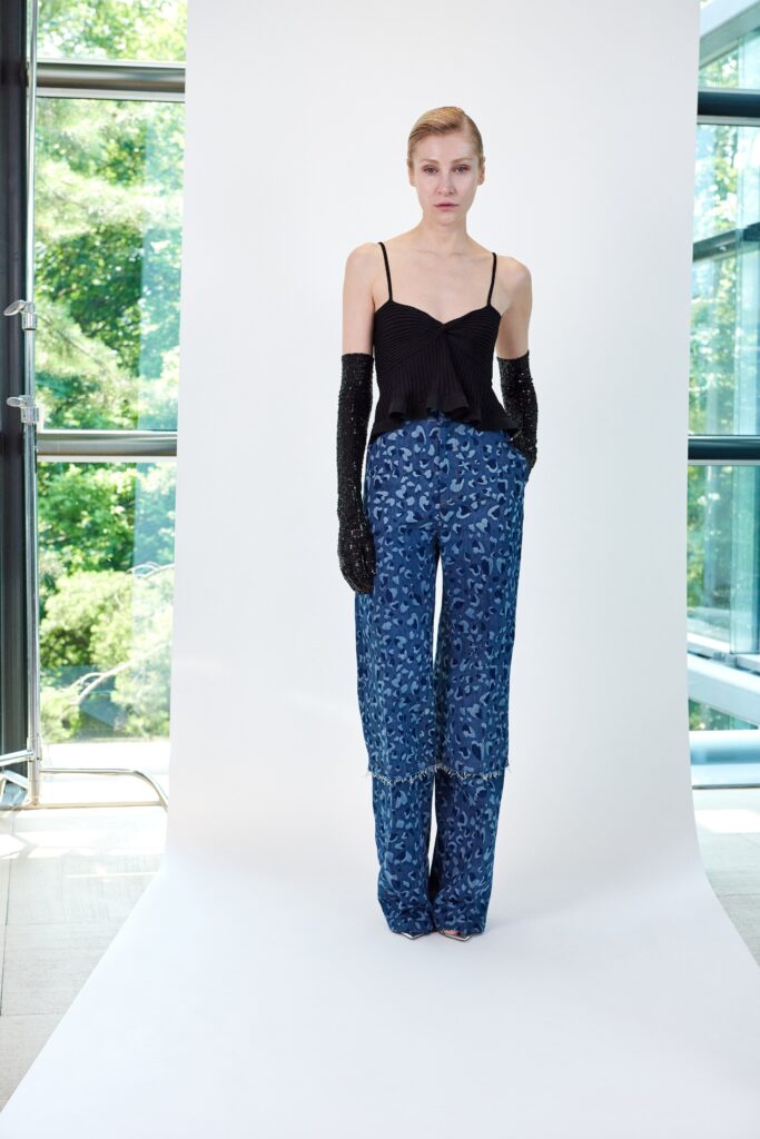 A fitted sleeveless blue printed top paired with black wide-leg pants.