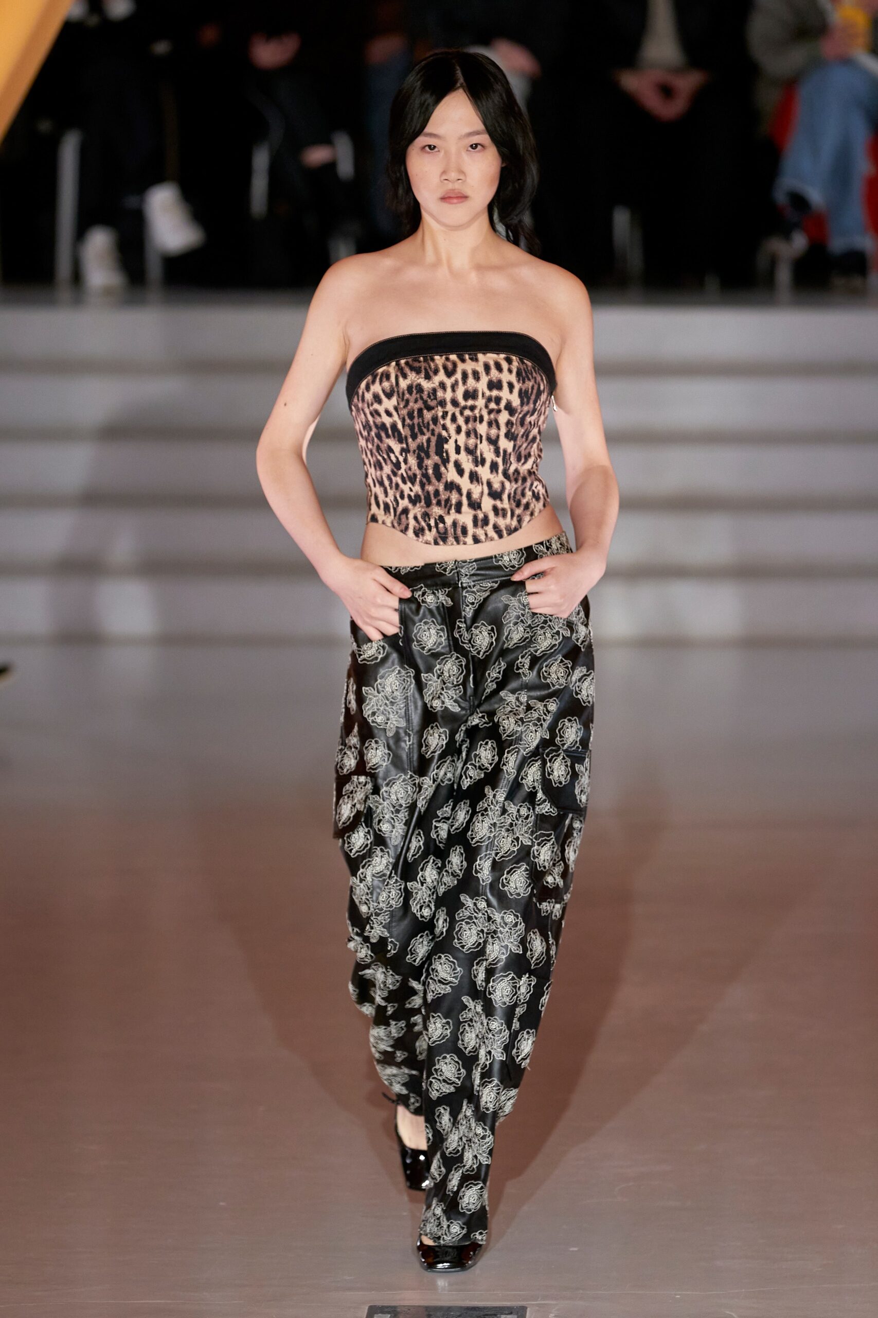 A fitted strapless top with a printed design paired with high-waisted black pants.