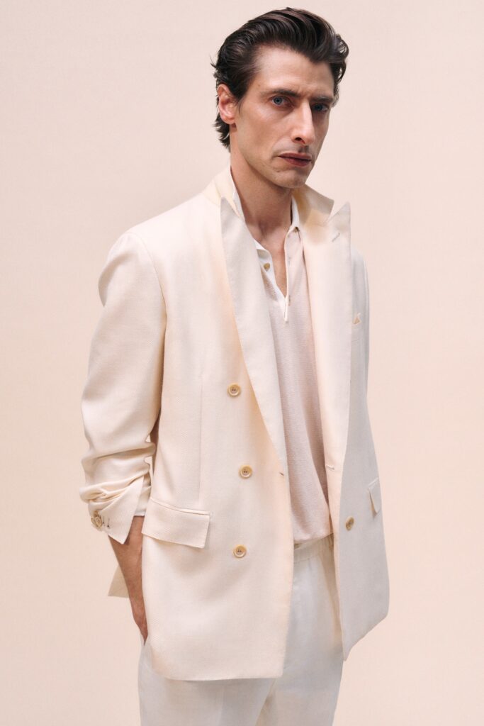 A relaxed beige blazer paired with a white collared shirt, featuring a buttoned design.