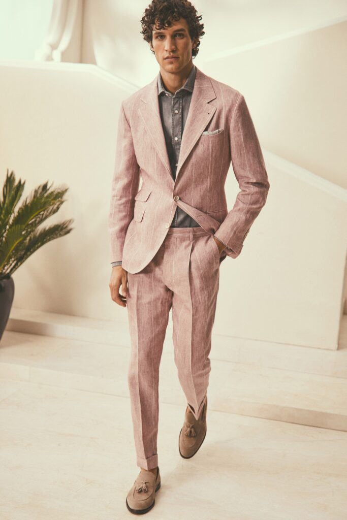 A tailored pink striped suit with a collared long-sleeve shirt underneath.