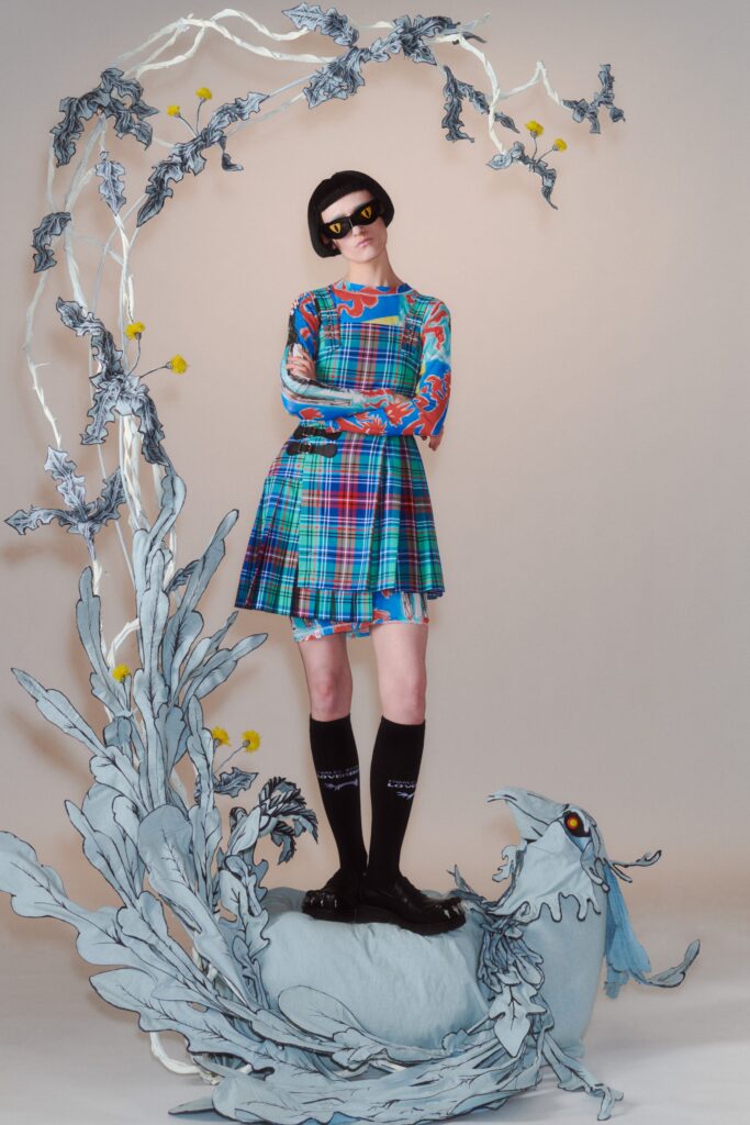 A fitted blue and green plaid dress with long sleeves and a collared neckline.