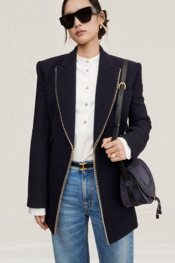 A fitted navy blazer with a white collared shirt, featuring button details.