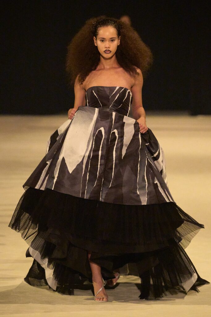 A fitted strapless black and white dress with a tiered silhouette and printed design.